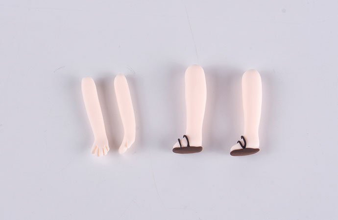 步骤5：用肤色黏土做出路飞的四肢，咖啡色黏土做出两只小鞋子粘好。