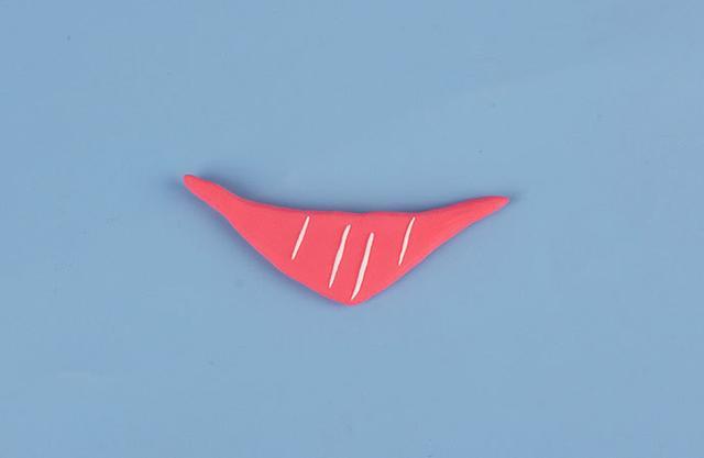 步骤8：用浅红色粘土做一个三角巾，上面装饰上白色纹路。