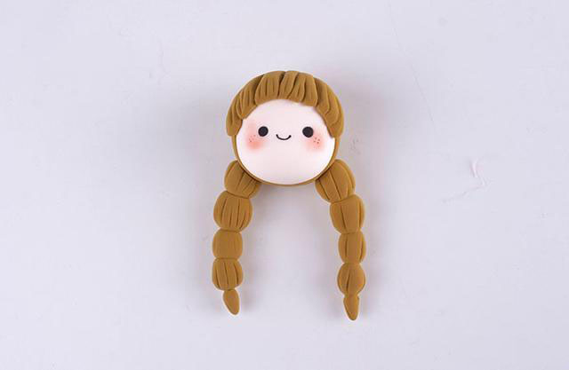 步骤4：把所有的头发粘好，并做好造型，还要把眼睛和嘴巴粘好。腮红也涂上。这样小女巫的头部就做好了。这样看起来是不是很可爱呢？