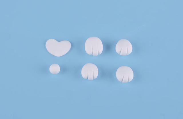 步骤9：白色粘土做出柯基的四只爪子，心形贴片，小圆球做尾巴。