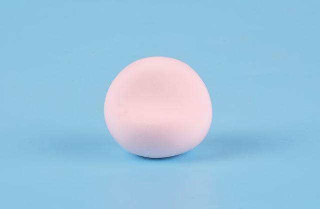 步骤1：首先我们用粉红色粘土揉一个圆球，然后用擀棒在脸部压一下，整理成上图的形状，这样更有立体感。