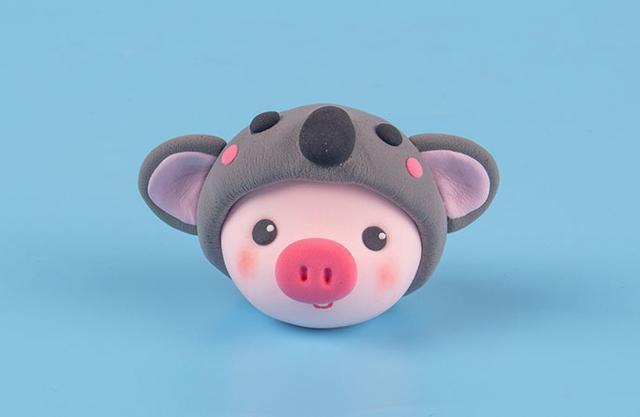 步骤6：把灰色小帽子戴到小猪头上，并把考拉的各个部件粘好，这样考拉帽子就做好了。