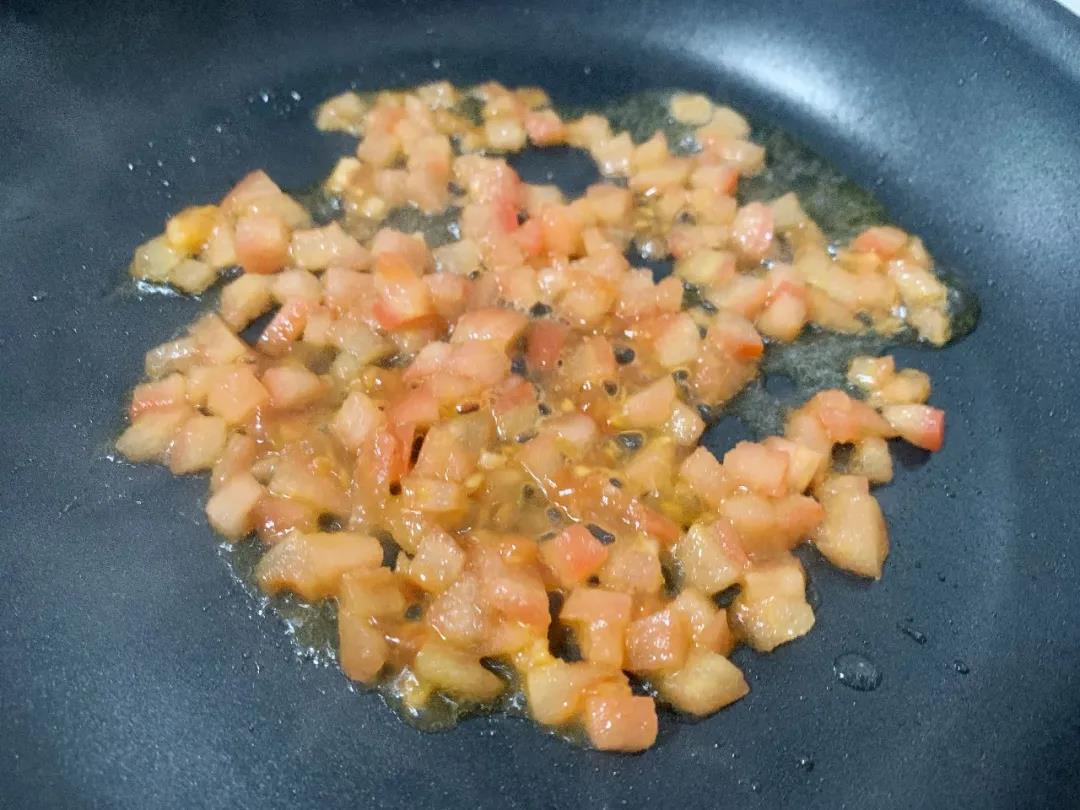 西红柿放入油锅，翻炒出汁、变软。