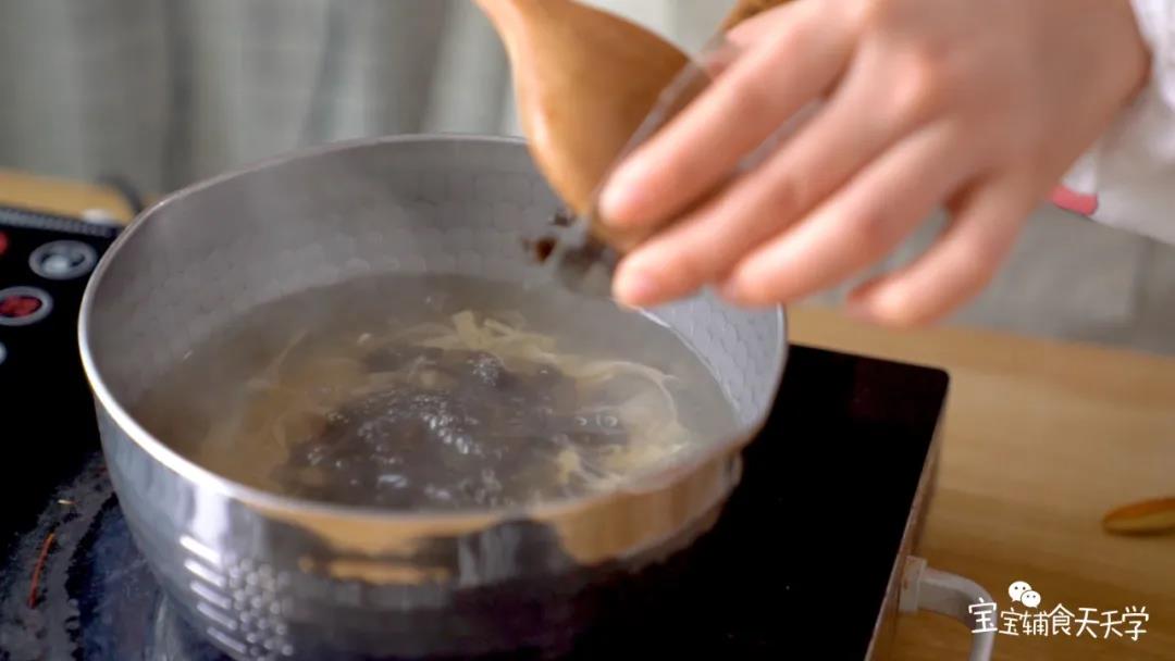 用小汤锅把水煮开后倒入木耳、腐皮