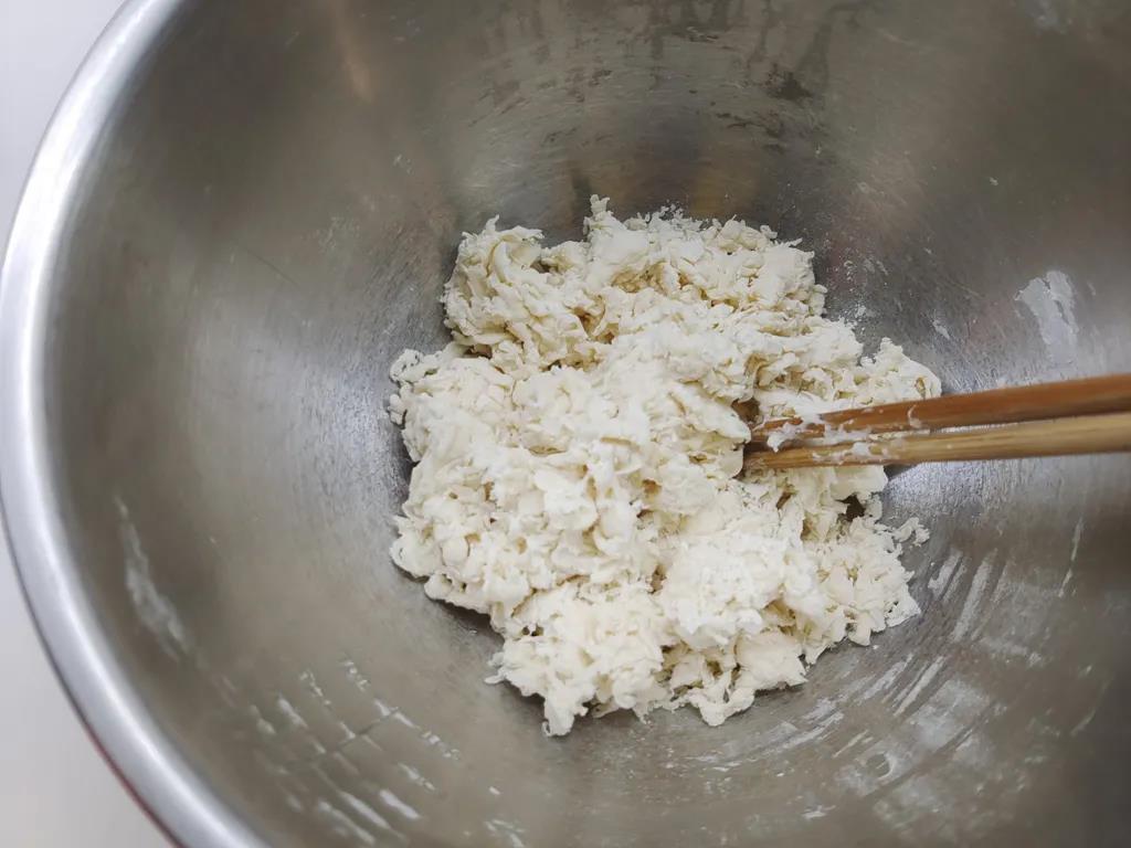 面粉和酵母水混合，用筷子搅拌均匀成大面絮。
