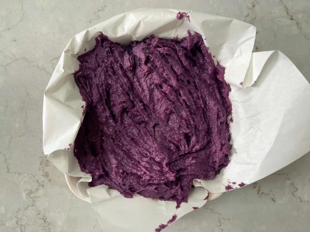 模具垫油纸，倒入面糊，把表面抹匀。