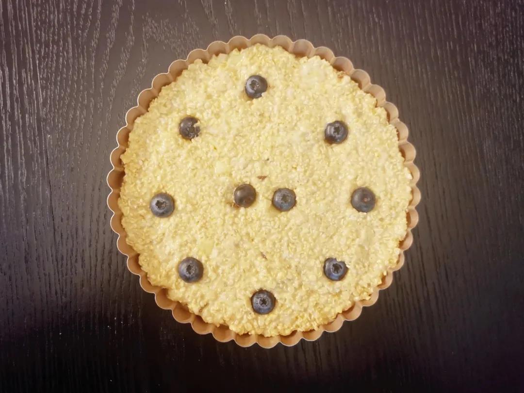  一起倒入派盘铺平，也可以用平底烤碗、四寸戚风模具等可以入烤箱的模具。铺好后均匀嵌入蓝莓。