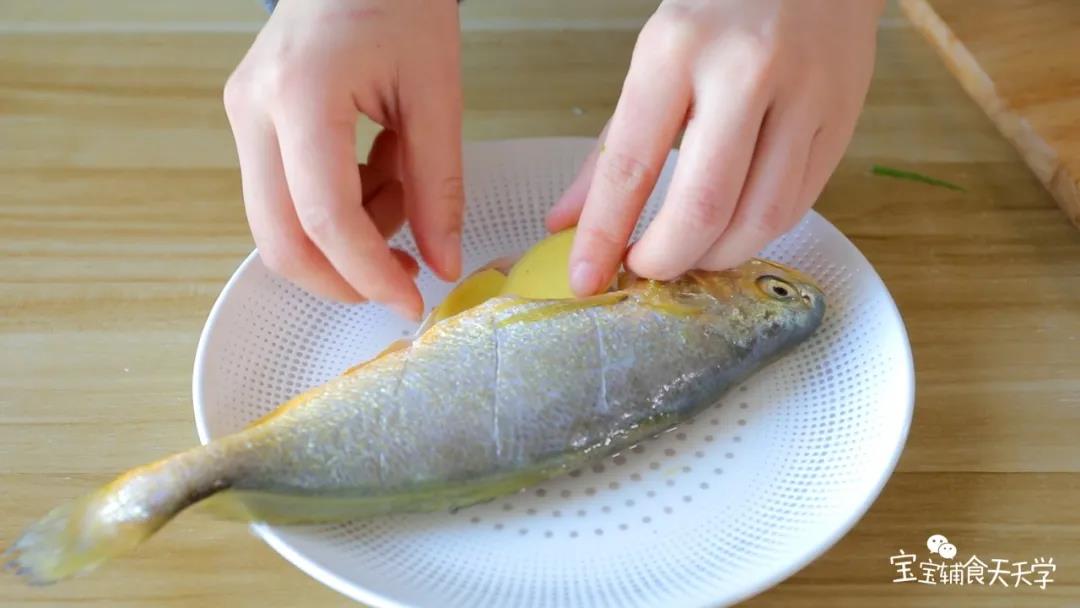 姜片和葱段铺在鱼两面上，稍微腌制十几分钟去腥