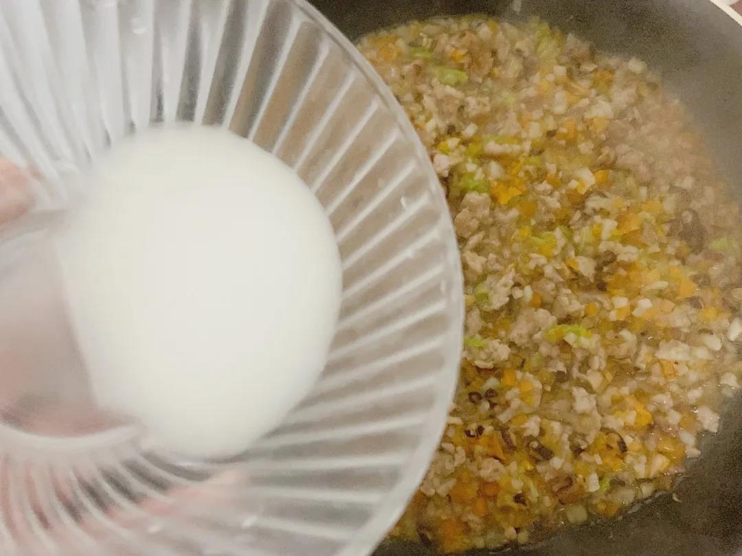 第8步：待锅内食材焖煮至水分开始变少时，边搅拌边均匀倒入水淀粉，煮至酱汁变浓稠。