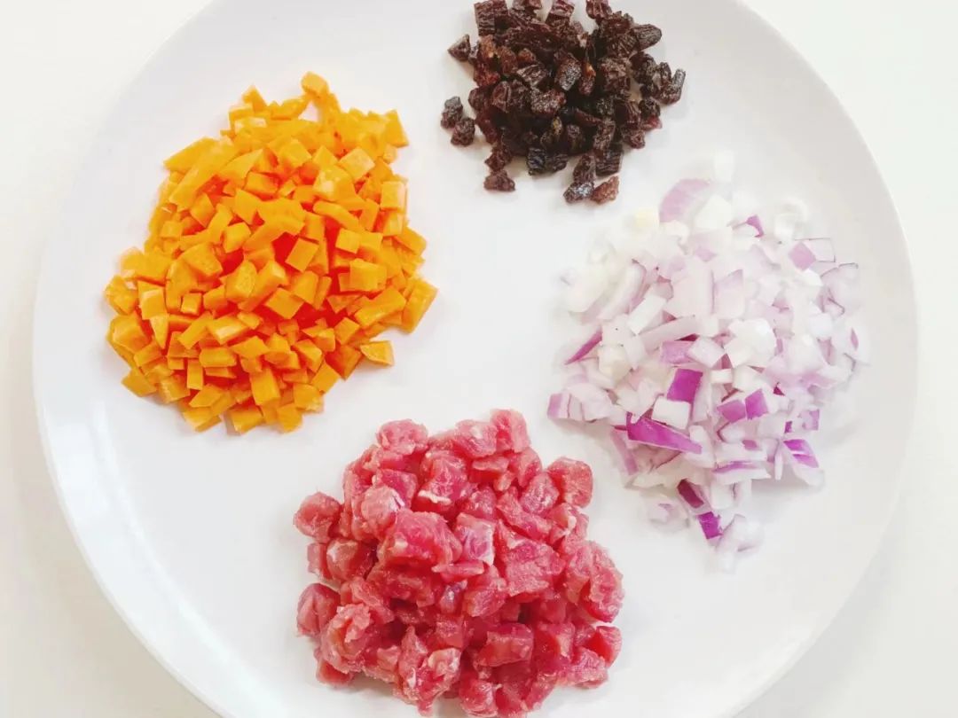 牛肉洗净切丁，胡萝卜、洋葱洗净去皮切丁，葡萄干洗净擦干切碎。