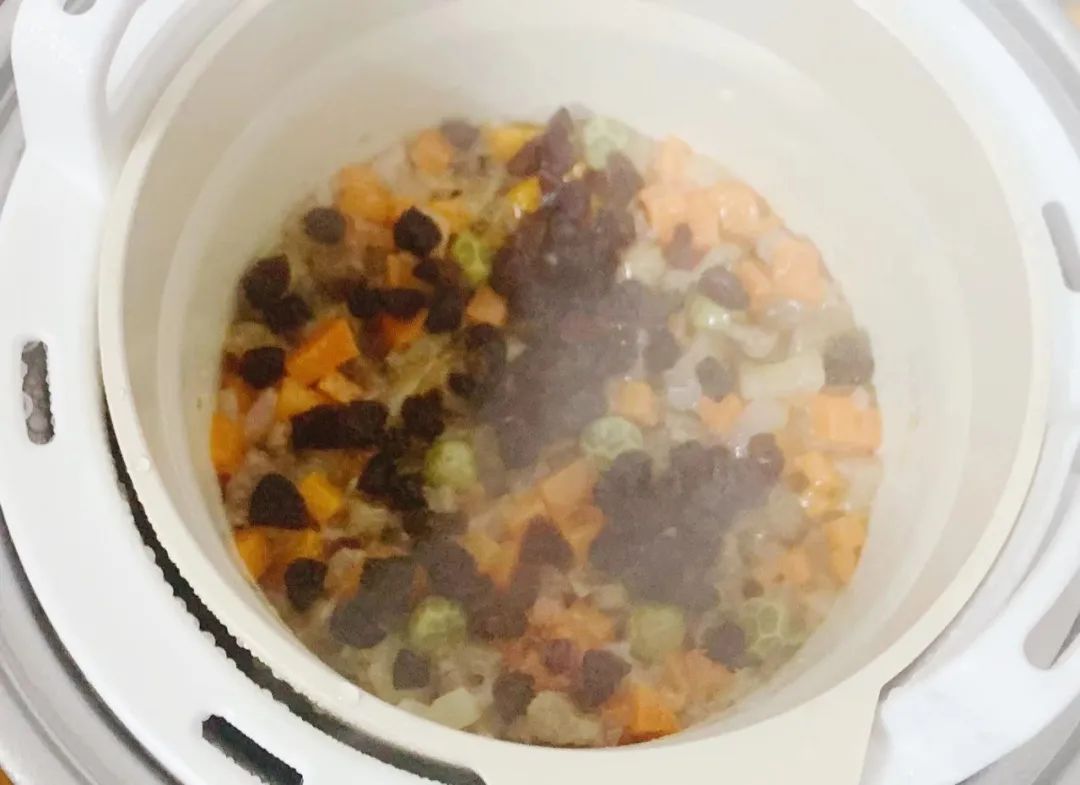 出锅前10分钟开盖，撒上葡萄干碎，继续盖盖焖煮至熟。