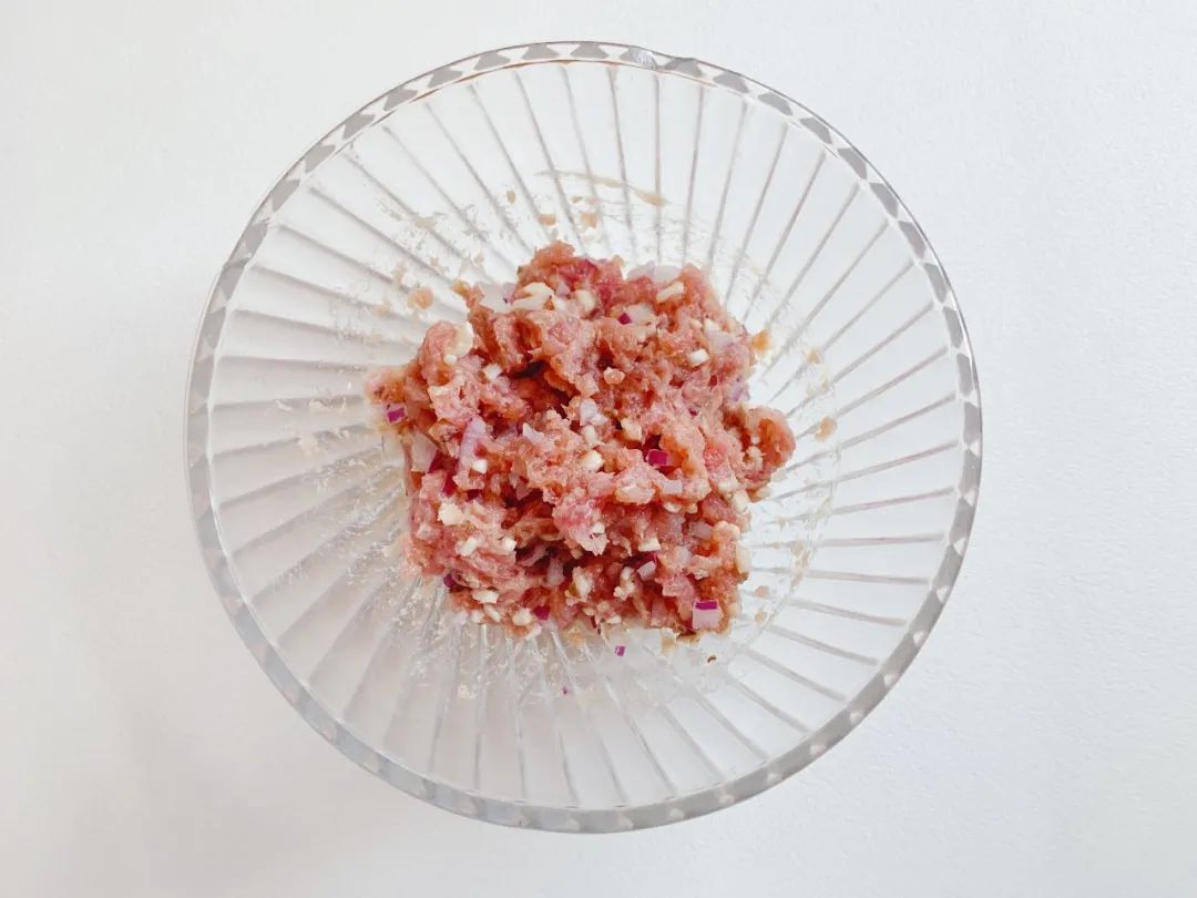 菜肉碎中加入油、淀粉，用筷子混合搅拌均匀。