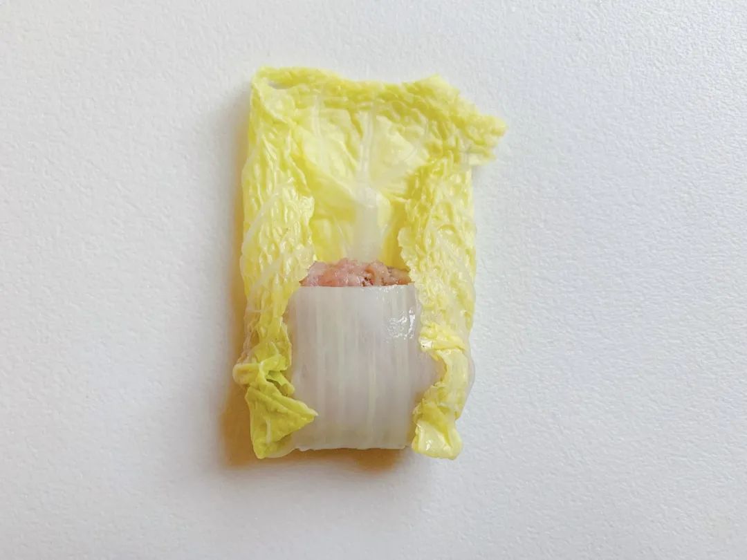 再将两侧的菜叶朝中间折。