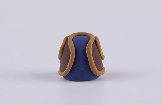 步骤9：把光头强的衣服粘好，用泥土色细条包上边。