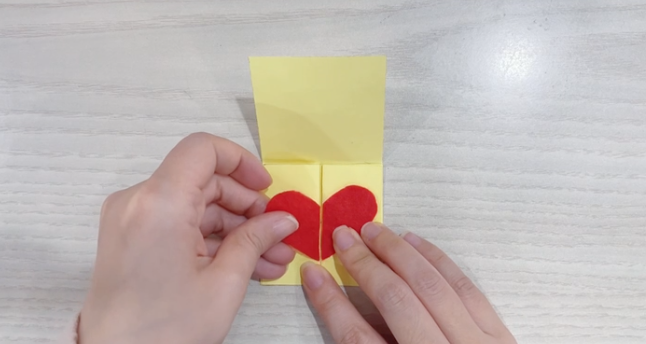 步骤3：红色卡纸剪成心形分别粘在两边。