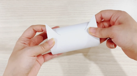 步骤3：另一个纸筒用铅笔画出猫耳朵的轮廓并用剪刀剪开。