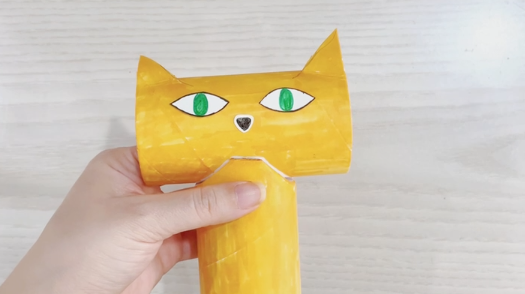 步骤6：用白色卡纸剪出猫的眼睛和鼻子，并上色贴在脸部。