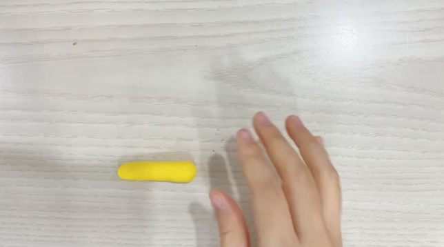 步骤1：黄色橡皮泥搓成长条形，  两端都整理得圆润一些。