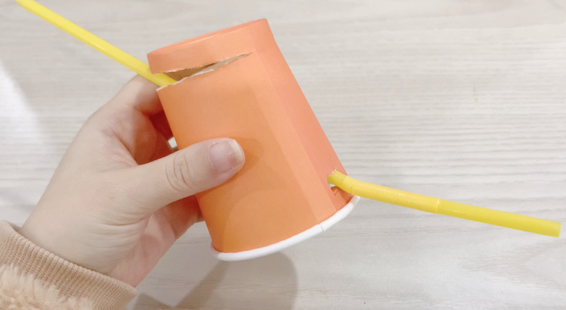 步骤3：一根吸管从小口子穿过去，剪去多余的部分。