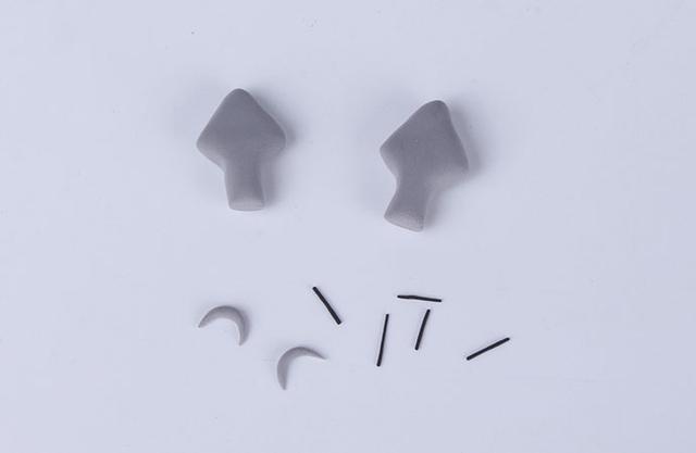 步骤5：先做龙猫的耳朵 ，灰色粘土做出箭头的形状，然后是龙猫身上的纹路，灰色粘土做出小月牙的形状，最后把黑色粘土揉成细条，然后剪成小段作为龙猫的胡须。