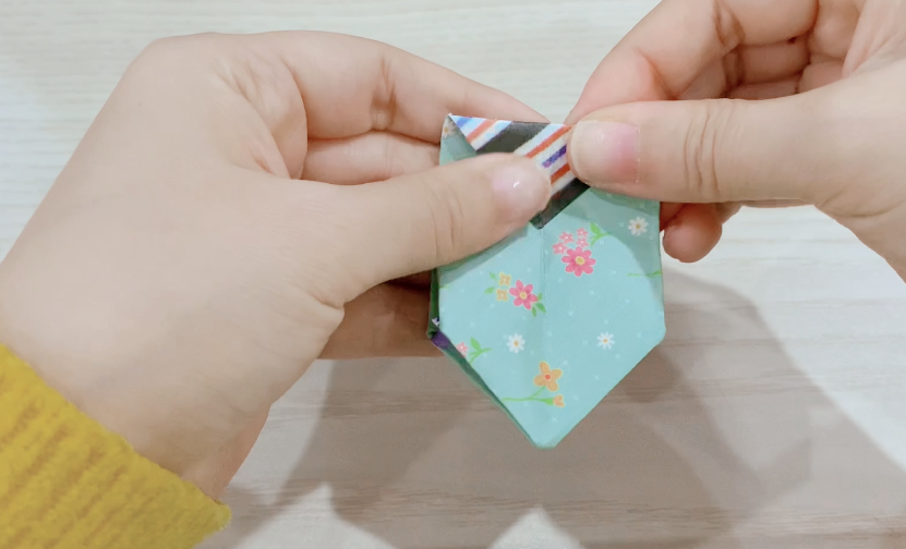 步骤6：展开两边，对半向下折。