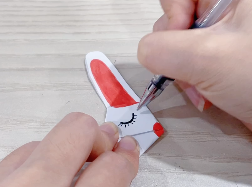 步骤5：拿彩笔画上兔子的耳朵，嘴巴和眼睛。