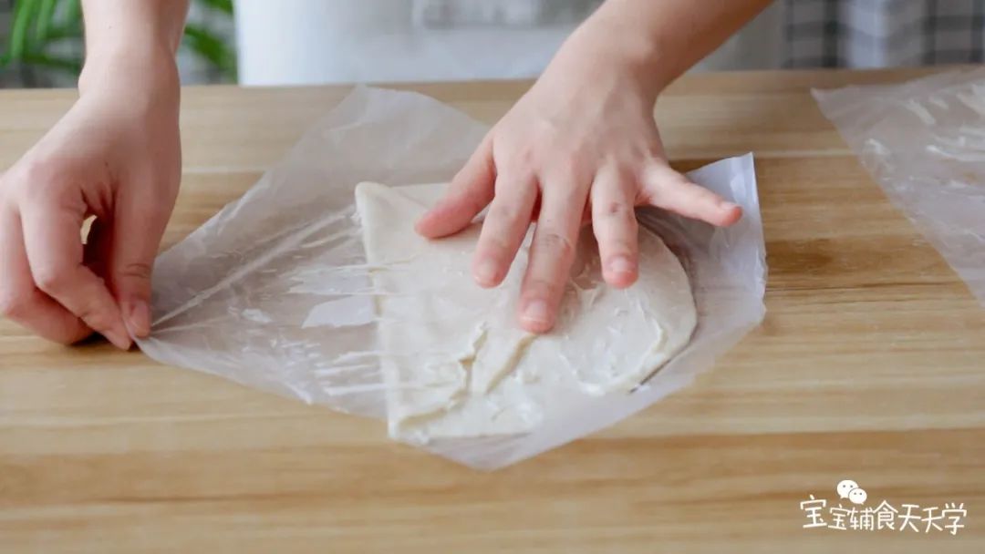先在砧板上刷油，放上手抓饼