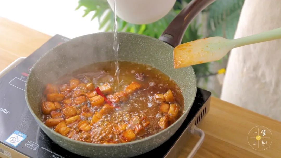 肉块均匀上色后，加入蚝油、生抽、八角、干辣椒、盐和热水，炖煮20分钟