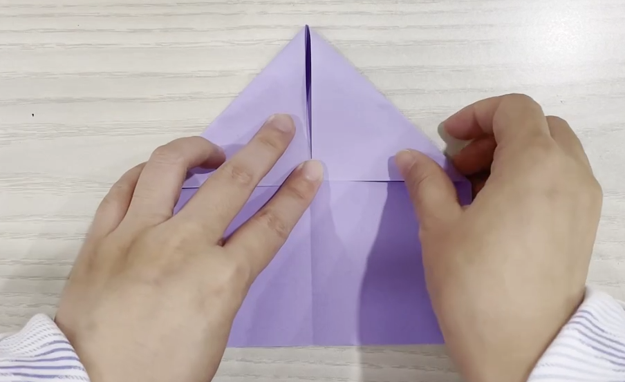 步骤2：一端向内折成三角形。