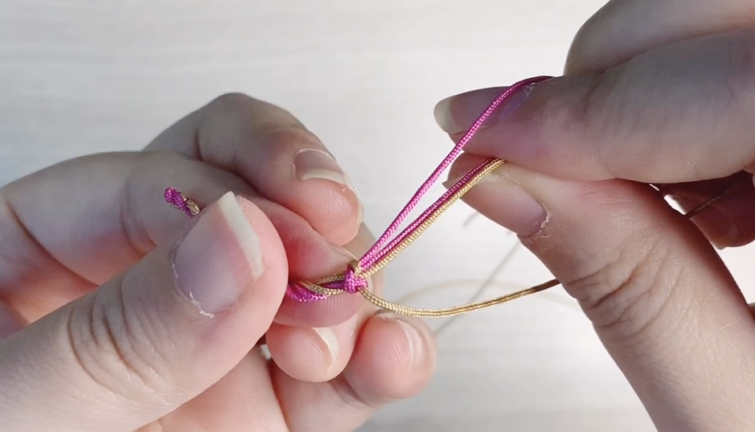 步骤6：先收紧黄线，再收紧红线。按照这个方法就可以开始编了。每编一股就整理一下松紧和位置。中间的短线也可以随时调整。