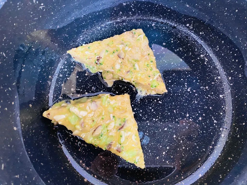锅里放油，取一片吐司均匀裹上鸡肉蔬菜蛋液，放入锅中小火烙。
