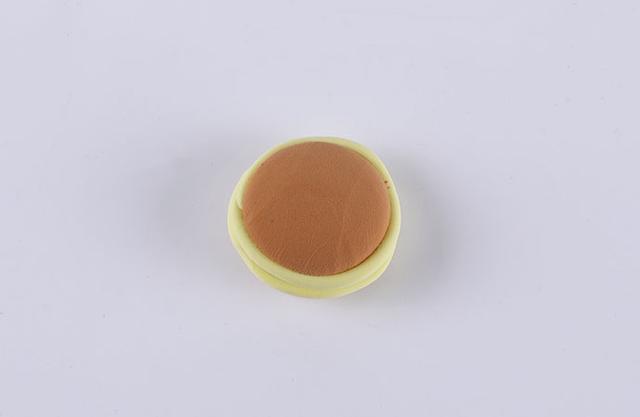 步骤11：用泥土色粘土做出两个小圆饼，然后柠檬黄色粘土揉细条粘在圆饼边缘，最后把两个小圆饼粘在一起，这就是哆啦A梦爱吃的铜锣烧。