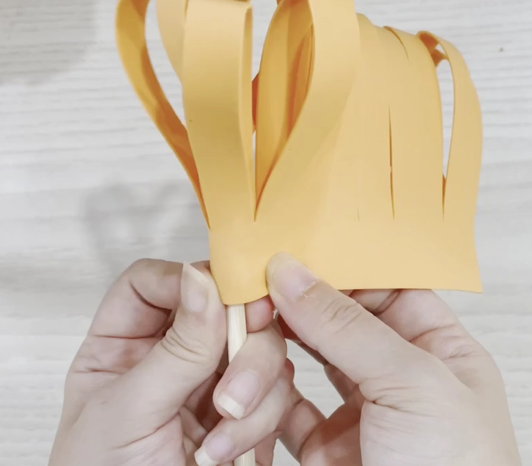 步骤5：用一根棍子，盘旋贴在一端。