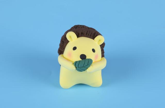 步骤9：把胳膊粘好并做好造型，让小刺猬拿着树叶挡着嘴巴，嗯，这就是大哥不言了。