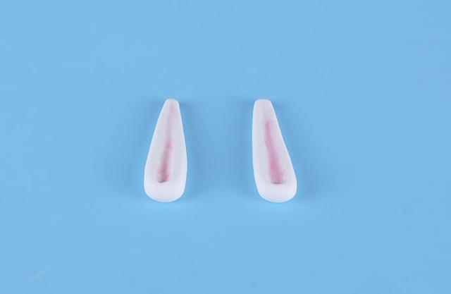 步骤4：用白色粘土做两个细长的水滴形，中间压一下做出小兔子的长耳朵。