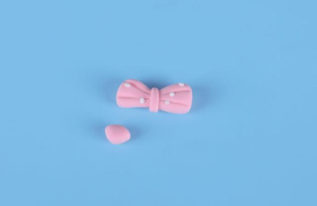 步骤2：然后用粉红色粘土做一个蝴蝶结，再做一个小鼻子