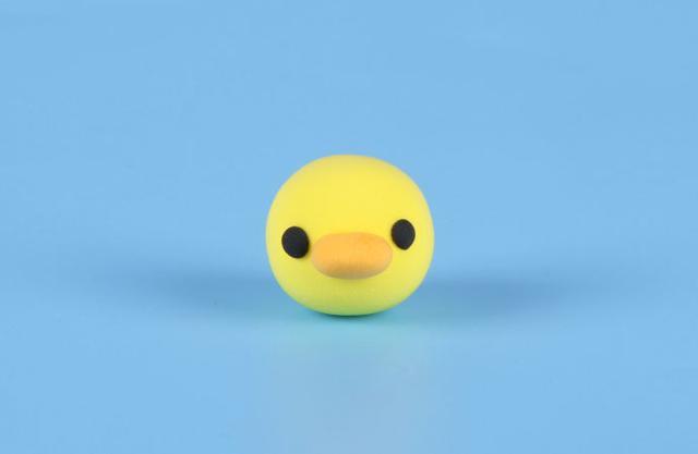 步骤4：按照上图的样子用黄色粘土做身体，黑色粘土做眼睛，橙色粘土做嘴巴，做一只小鸭子出来。