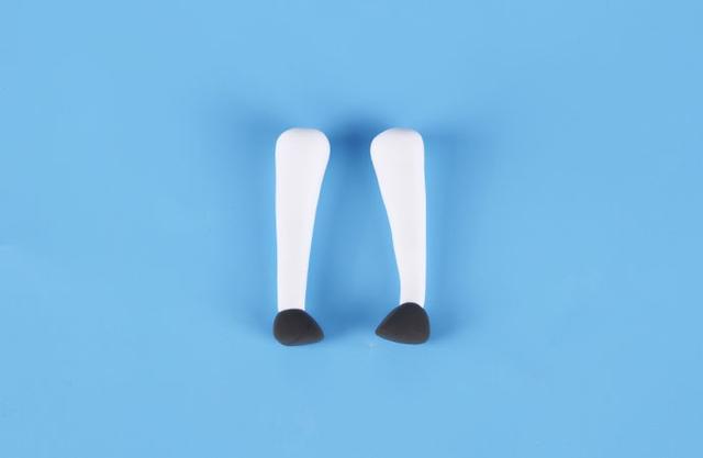 步骤7：白色粘土揉成细长的水滴形，然后细的一端粘上黑色的三角形粘土，这是麋鹿的双腿。