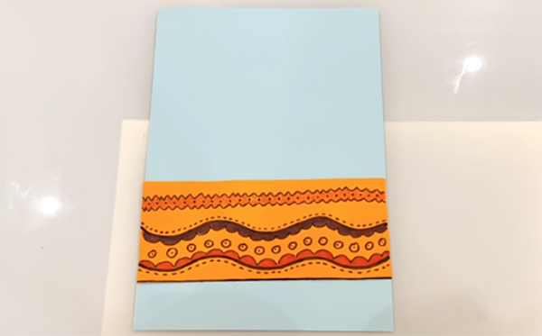 步骤4：选一张其他颜色的长条卡纸当做花盆，画出你喜欢的花纹。