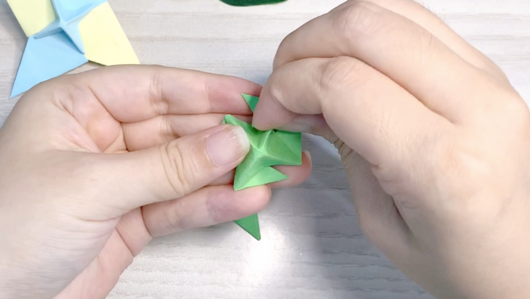 步骤14：反过来四角向中心折，凸出的三角向左折。