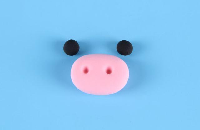 步骤2：然后用黑色粘土做出眼睛，粉红色粘土做出牛嘴巴部分。