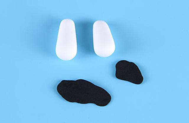 步骤7：白色粘土揉两个水滴形作为胳膊，然后做出不同形状的黑色斑点。