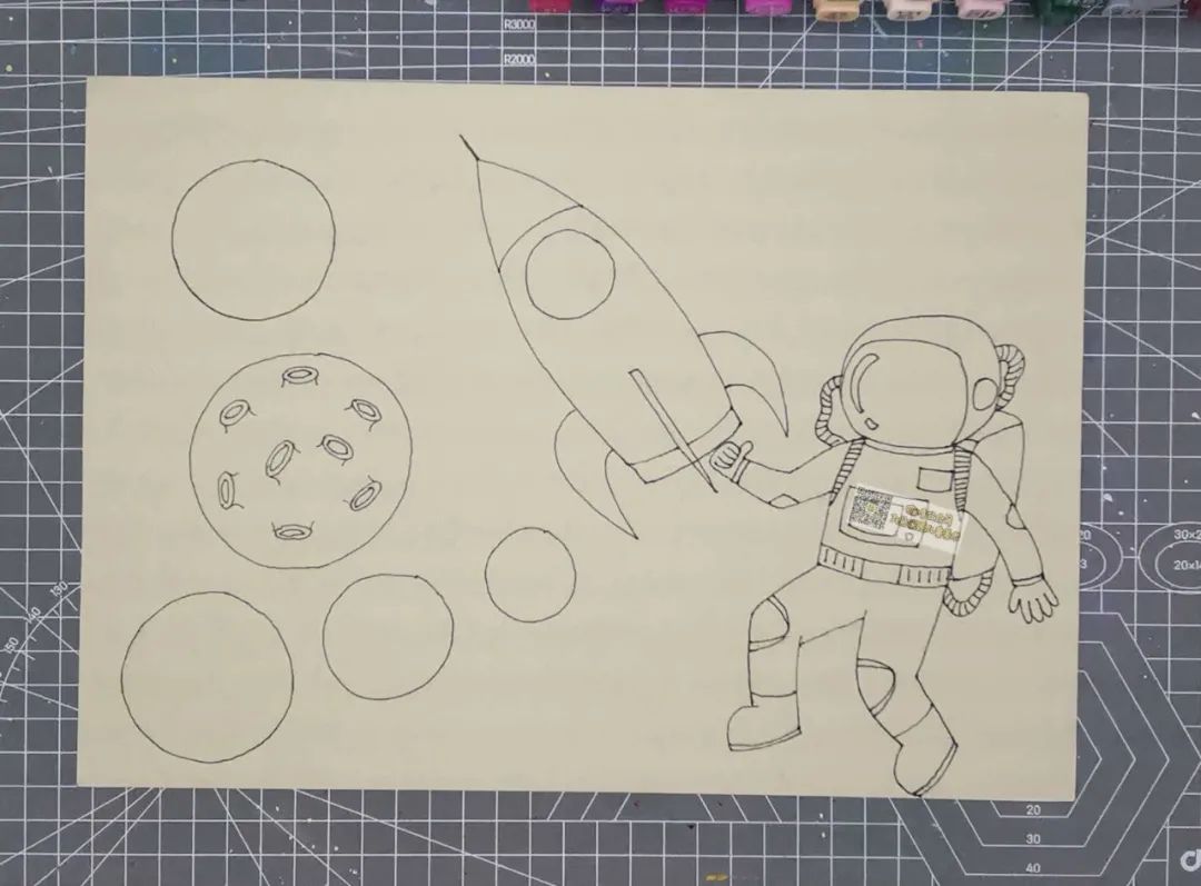 步骤1：白纸上画出宇航员、飞船和几个大小不同的圆形。