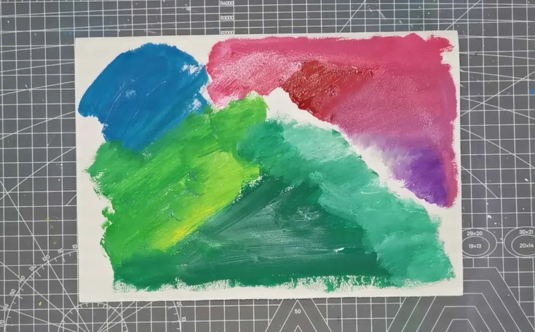 步骤2：白纸上画上水粉颜色，有的画桔为画金丝猴做准备，有的画蓝色是做金丝猴的脸，有的画深浅不同的绿色准备做树叶。画好后放一边晾干。