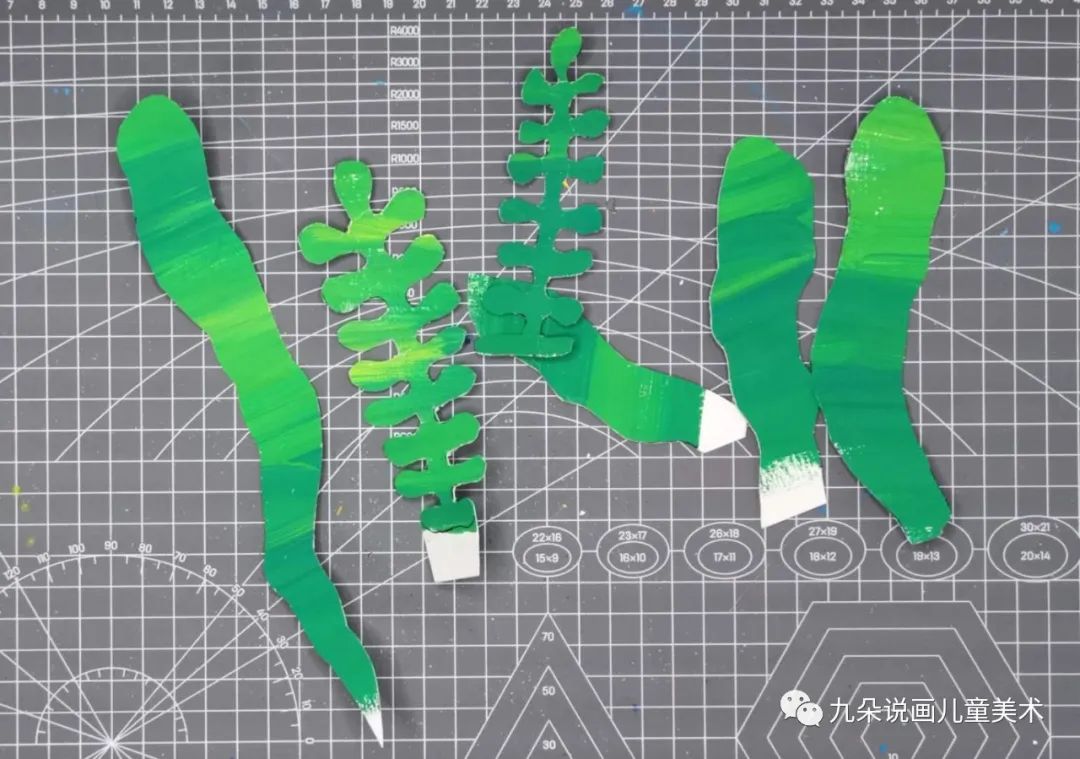 步骤4：水粉也干了，这时我们用绿色的纸画出水草，灰色的画石头，彩色的画珊瑚和珊瑚虫。画好后用剪刀剪下，年纪小的同学可以画一些简单造型的水草珊瑚来剪。