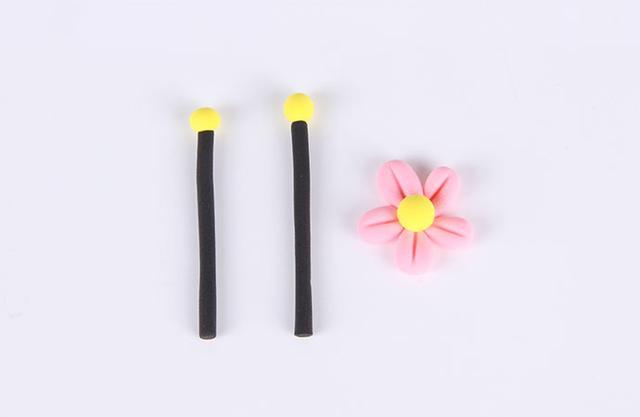 步骤10：最后做小蜜蜂的触角以及装饰用的小花朵，黑色粘土揉细条，顶部粘上黄色小圆球作为触角。然后再做一朵粉红色的小花。