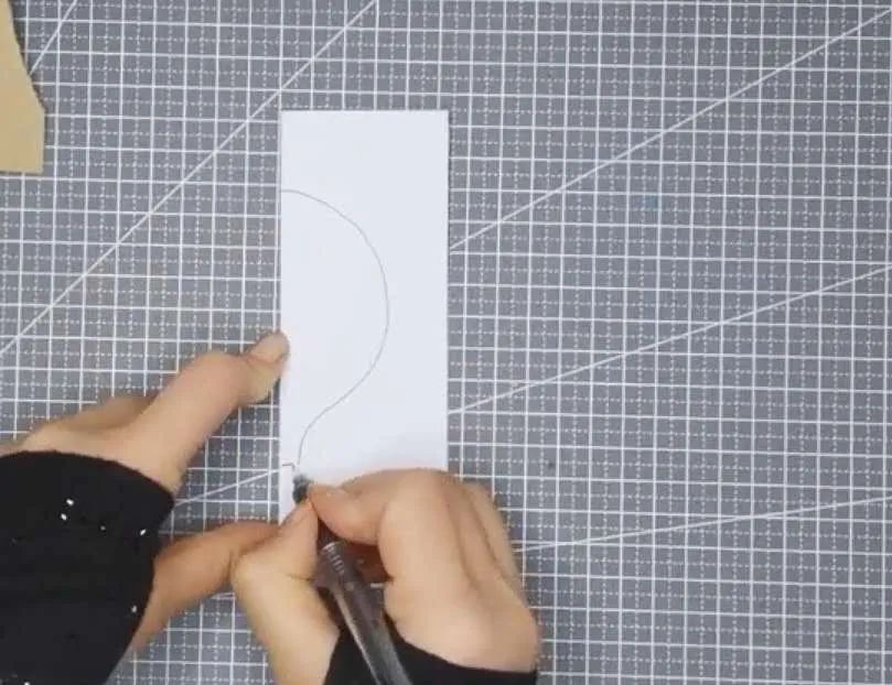 步骤5：取白纸，对折后再对折，用笔画出半个热气球的形状，并用剪刀沿着画的线剪下。