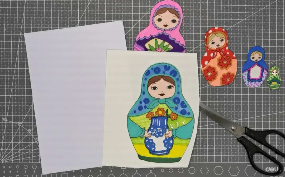 步骤4：画好后用剪刀沿着轮廓剪下来。这里再取一张白纸，和最大的套娃叠在一起剪，剪出一个一模一样的空白套娃轮廓。