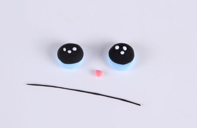 步骤3：按照上图的样子用天蓝色和黑色粘土做出眼睛，白色粘土搓小球点缀一下。粉红色粘土做一个小鼻子，黑色粘土揉一根细条备用。
