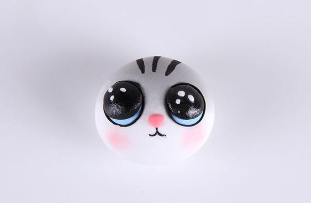 步骤4：把做好的眼睛和鼻子粘好，然后用黑色粘土细条做出眼圈和嘴巴，最后涂上腮红。